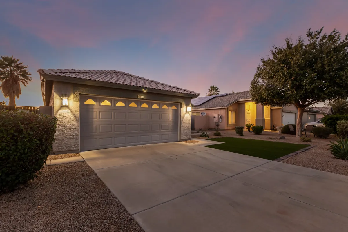 An exterior view featuring the garage door, landscaped front yard, and a clear driveway leading to the entrance. The image suggests ample, private parking and a welcoming approach to the home.