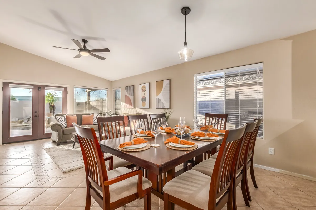 A warm, inviting dining area with a sturdy table, comfortable chairs, and decorative artwork on the wall. The adjacent seating area suggests a seamless flow between dining and relaxing, ideal for hosting memorable meals or game nights.